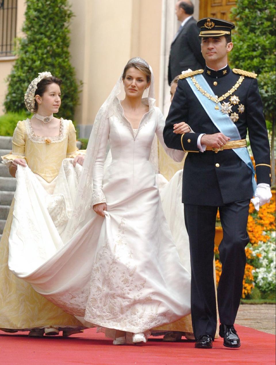 <p>The always chic Queen Letizia walked down the aisle in a collared <span class="redactor-unlink">Manuel Pertegaz</span> gown that featured a stunning train.</p>