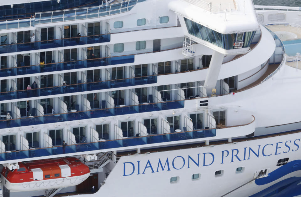 Some passengers are seen on the Diamond Princess as the cruise ship is anchored at Yokohama Port for supplies replenished in Yokohama, south of Tokyo.