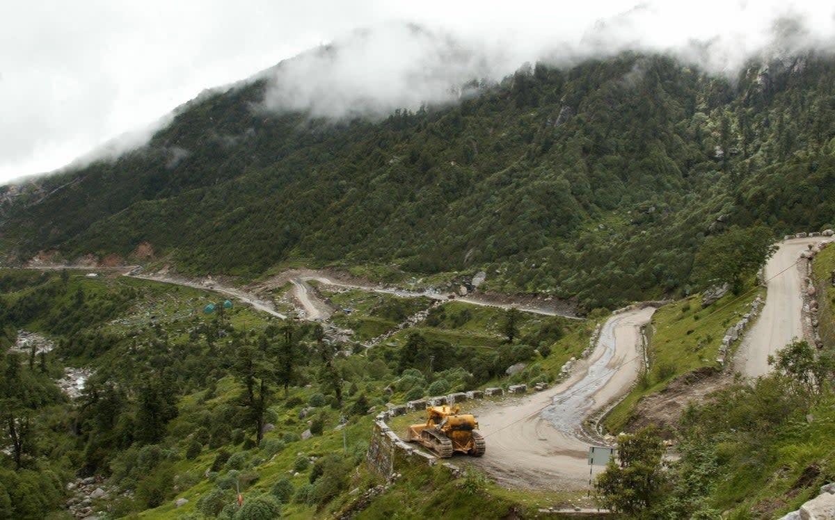 In this file photo taken on 10 July 2008, a bulldozer makes its way along the Nathu La Pass  (AFP via Getty Images)