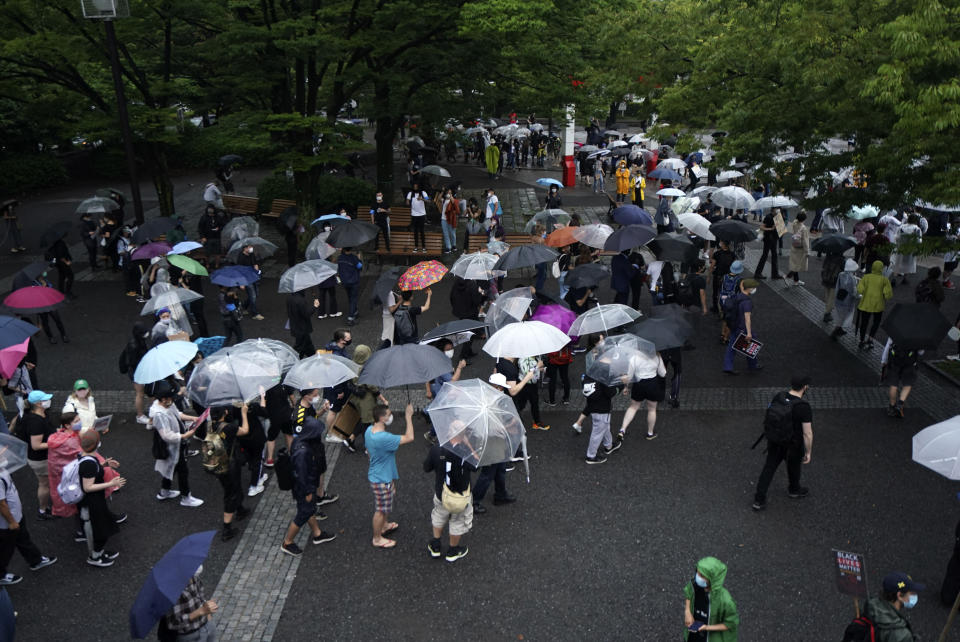 People march in the rain to protest during a solidarity rally for the death of George Floyd in Tokyo Sunday, June 14, 2020. Floyd died after being restrained by Minneapolis police officers on May 25. (AP Photo/Eugene Hoshiko)