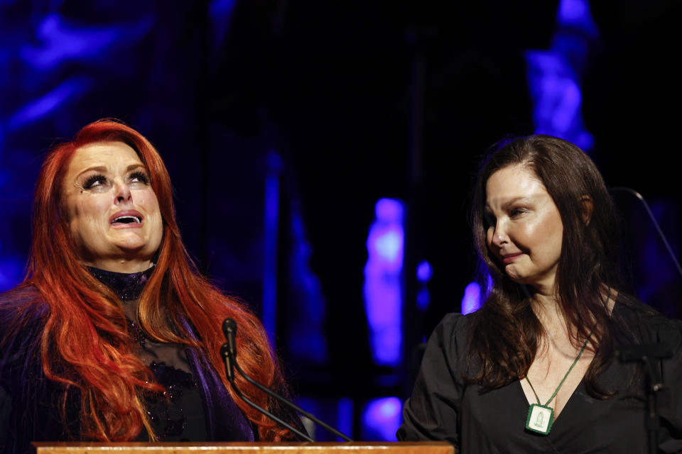 Wynonna Judd, left, looks to the sky as sister Ashley Judd watches during the Medallion Ceremony at the Country Music Hall Of Fame Sunday, May 1, 2022, in Nashville, Tenn. (Photo by Wade Payne/Invision/AP)