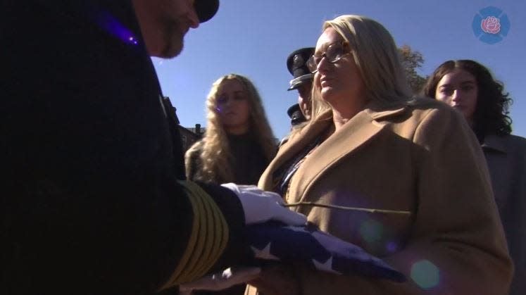 Jacksonville Fire and Rescue Department Capt. Thomas Barber's family accepts a folded American flag during National Fallen Firefighters Memorial ceremonies over the weekend.