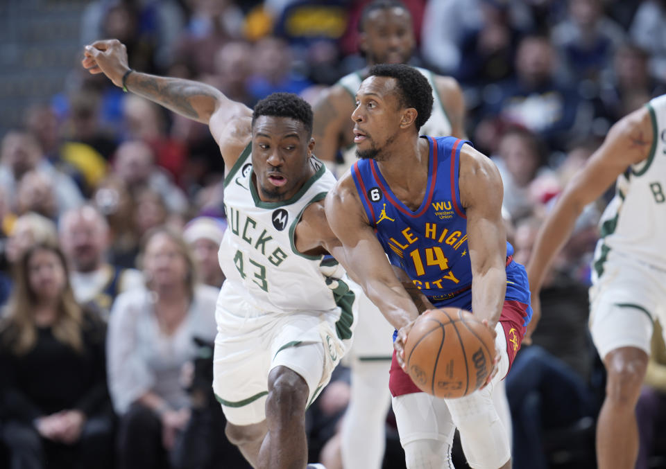 Denver Nuggets guard Ish Smith, right, pulls in the ball as Milwaukee Bucks forward Thanasis Antetokounmpom left, defends in the second half of an NBA basketball game Saturday, March 25, 2023, in Denver. (AP Photo/David Zalubowski)