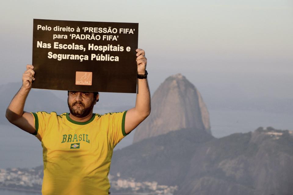 A member of NGO Rio de Paz holds a sign during a protest against the 2014 World Cup in Rio de Janeiro