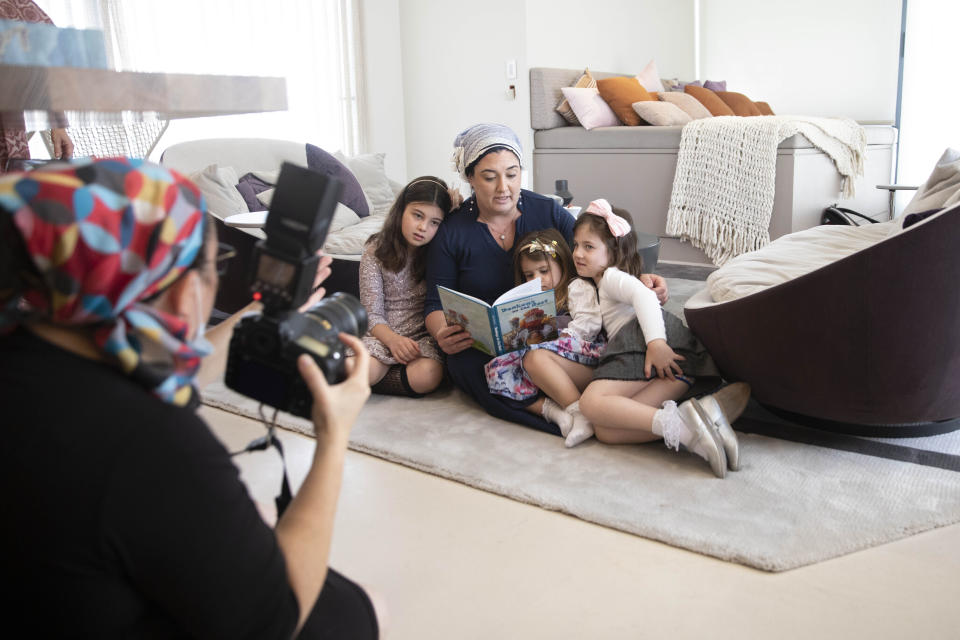 FILE - In this Aug. 26, 2021, file photo, a photographer takes a picture of an Ultra-Orthodox woman with her children for a photoshoot for the subscription-only Jewish Life Photo Bank of what the founder calls “positive” images of Orthodox women for the Chochmat Nashim organization. The idea of the photo bank is to sell images of women that are acceptable to an Orthodox audience, and better understood by people in general. (AP Photo/Sebastian Scheiner, File)