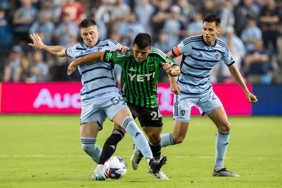 Sporting Kansas City midfielder Rémi Walter (left) and teammate forward Dániel Sallói (right) battle Austin FC defender Nick Lima during Saturday’s match at Children’s Mercy Park in Kansas City, Kansas.