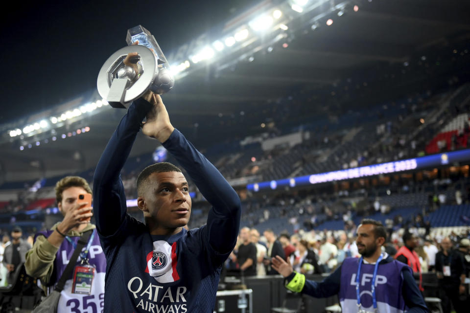 CORRECTS TO SAY THAT PSG LOST TO CLERMONT BUT WON TITLE- Paris Saint-Germain's French forward Kylian Mbappe holds up his trophy during the ceremony following the team's French League One soccer match loss to Clermont, in Paris, Saturday, June 3, 2023. Despite the loss, PSG finished as the French league champion. (Franck Fife/Pool Photo via AP)