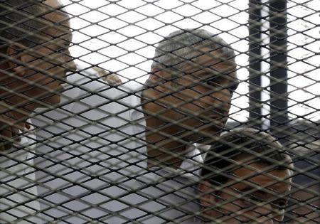 Peter Greste, Mohamed Fahmy and Baher Mohamed (L to R) listen to a ruling at a court in Cairo June 23, 2014. REUTERS/Asmaa Waguih