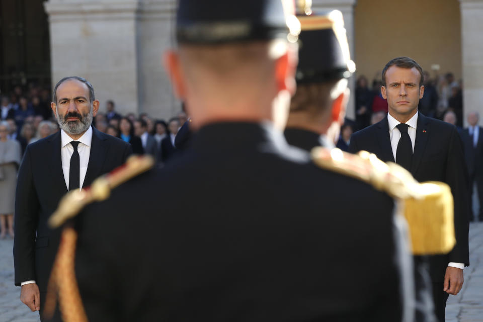 El primer ministro armenio Nikol Pashinian, izquierda, y el presidente francés Emmanuel Macron rinden homenaje al fallecido cantante Charles Aznavour en una ceremonia en el patio de Les Invalides el 5 de octubre de 2018 en París. Aznavour murió a los 94 años tras una carrera que se extendió por ocho décadas en las que hizo brillar a la canción francesa. (Foto AP/Christophe Ena, Pool)