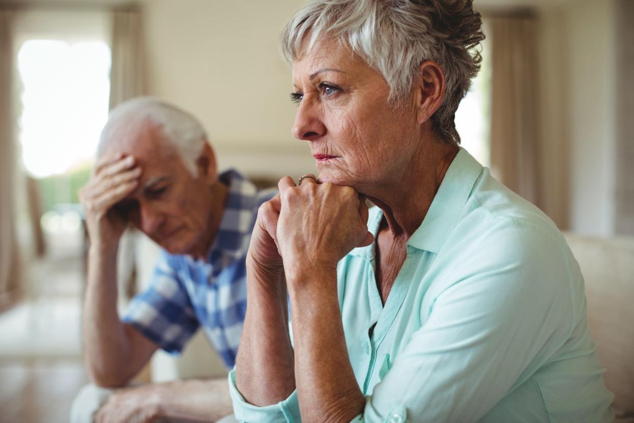 Upset senior couple relaxing on sofa