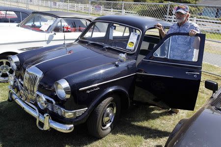 New owner John Yosgott poses with his 1959 Riley Saloon at the Mecum car auction in Monterey, California, August 16, 2014. REUTERS/Michael Fiala