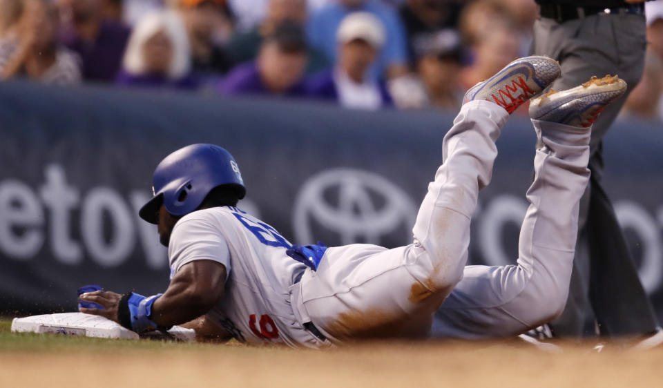 Los Angeles Dodgers' Yasiel Puig steals third base against the Colorado Rockies in the seventh inning of a baseball game Saturday, Aug. 11, 2018, in Denver. (AP Photo/David Zalubowski)