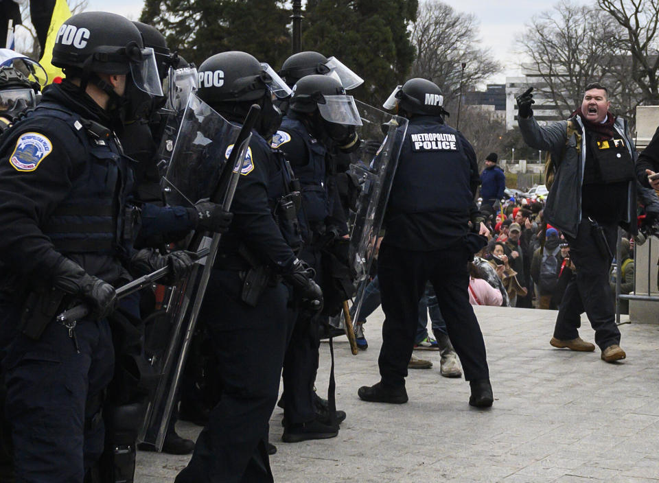 Russ Taylor, right, flips off cops at the Capitol. (Photo: ANDREW CABALLERO-REYNOLDS via Getty Images)