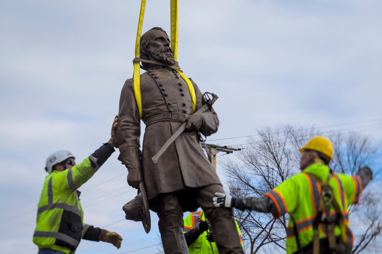 Workers begin to lay the bronze statue of Confederate General A.P. Hill onto a flatbed truck on Monday Dec. 12, 2022 in Richmond, Va. Workers are still planning to exhume the remains of General Hill which located inside the base of the statue.