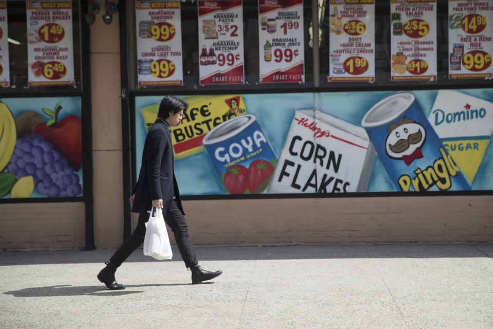 FILE - In this March 27, 2019, file photo a man leaves a supermarket in the East Village neighborhood of Manhattan carrying his groceries in a plastic bag. A growing number of states, counties and cities have passed legislation prohibiting or restricting retailers and other businesses from giving customers single-use plastic bags to carry purchases. Oregon's ban went into effect Jan. 1, 2020 and Maine, New York state and Vermont have similar prohibitions going into effect later in the year. (AP Photo/Mary Altaffer, Fil)