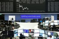 Traders work at their desks in front of the German share price index, DAX board, at the stock exchange in Frankfurt, Germany, February 28, 2017. REUTERS/Staff/Remote