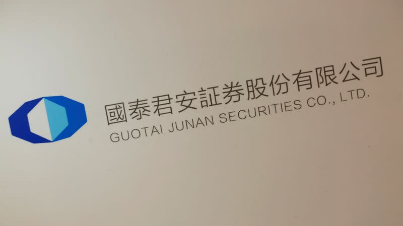 FILE PHOTO: A logo of Guotai Junan Securities is displayed at a news conference in Hong Kong