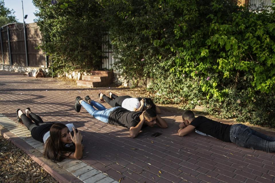 Israelis lie on the ground during an air raid.