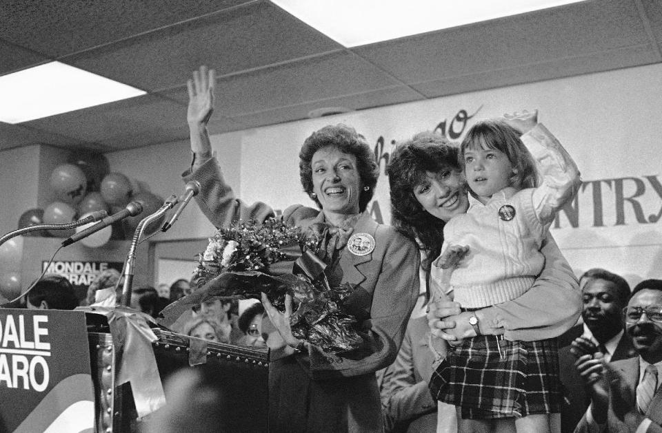 FILE - In this Sept. 10, 1984 file photo, Joan Mondale, wife of the Democratic presidential candidate Walter Mondale, center, waves to the campaign workers gathered at the Illinois headquarters for the Mondale-Ferraro election effort, in Chicago. Mondale is flanked by campaign worker Julie Grace, holdings Lauren Jascula, who also wanted to show her support. Joan Mondale, who burnished a reputation as "Joan of Art" for her passionate advocacy for the arts while her husband was vice president and a U.S. ambassador, died Monday, Feb. 3, 2014. She was 83. (AP Photo/Charlie Knoblock, File)