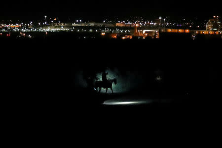 Border Patrol agents on horses track a man along the Rio Grande River after he illegally crossed into the U.S. from Mexico in Sunland Park, New Mexico, U.S., June 15, 2018. REUTERS/Adrees Latif