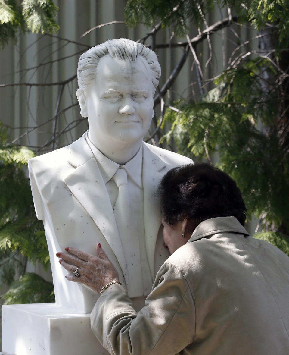 A woman kisses a bust of former strongman Slobodan Milosevic during funeral of his wife Mirjana Markovic at the yard of his estate in his home town of Pozarevac, Serbia, Saturday, April 20, 2019. Markovic died last week in Russia where she had been granted asylum. The ex-Serbian first lady had fled there in 2003 after Milosevic was ousted from power in a popular revolt and handed over to the tribunal in The Hague, Netherlands. (AP Photo/Darko Vojinovic)