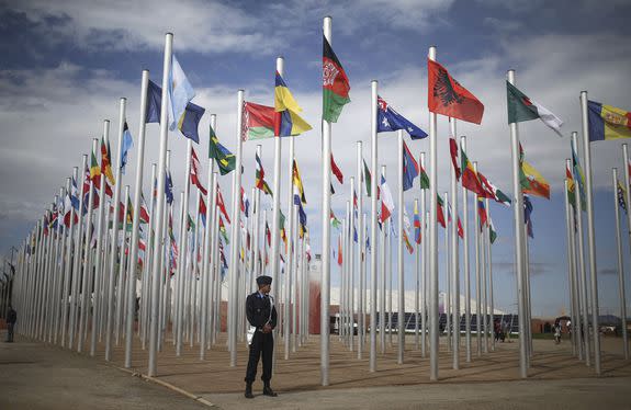 A  security stands guard next to flags of participating countries at the U.N. climate  change conference in Marrakesh, Morocco,  Nov. 6, 2016.