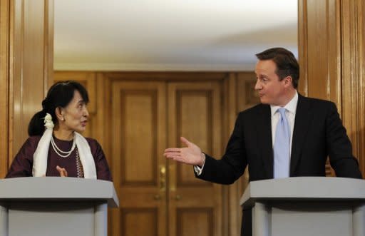 British Prime Minister David Cameron (right) gestures toward Myanmar democracy icon Aung San Suu Kyi during a joint press conference at 10 Downing Street in London. Suu Kyi urged the world to help Myanmar complete its journey towards democracy as she became the first foreign woman to address both houses of Britain's parliament