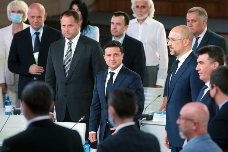 A photograph of Ukrainian governmental officials surrounding President Zelenskyy.