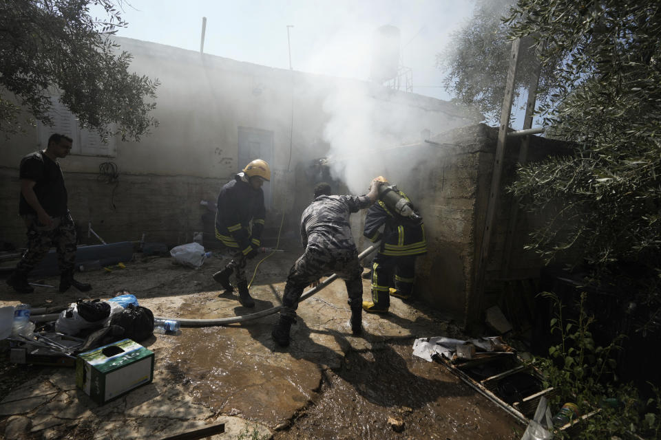 Palestinian firefighters try to extinguish a fire set by Jewish settlers in the West Bank town of Turmus Ayya, Wednesday, June 21, 2023. Israeli settlers entered the town, setting fire to Palestinian cars and homes after four Israelis were killed by Palestinian gunmen in the northern West Bank on Tuesday. (AP Photo/Majdi Mohammed)