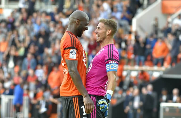 Lorient's defender Michael Ciani (L) and goalkeeper Benjamin Lecomte celebrate their team's victory against Lyon