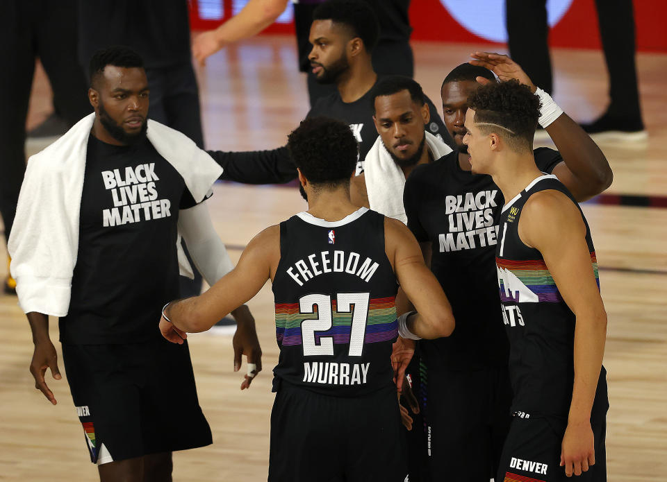 Jamal Murray, center, of the Denver Nuggets, reacts with teammates after their win over Utah Jazz in Game 5 of an NBA basketball first-round playoff series, Tuesday, Aug. 25, 2020, in Lake Buena Vista, Fla. (Mike Ehrmann/Pool Photo via AP)