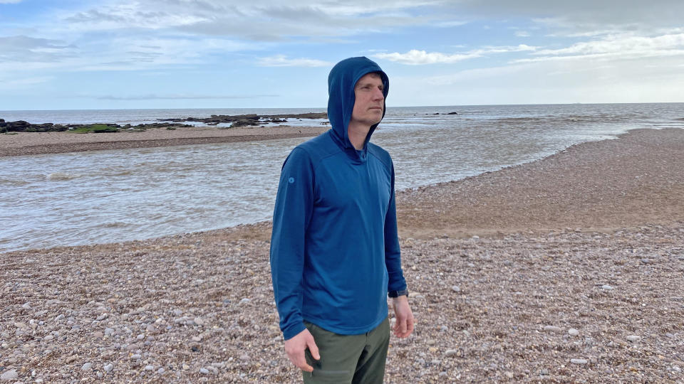 Man on beach wearing Smartwool Men's Active Mesh Hoodie with hood up