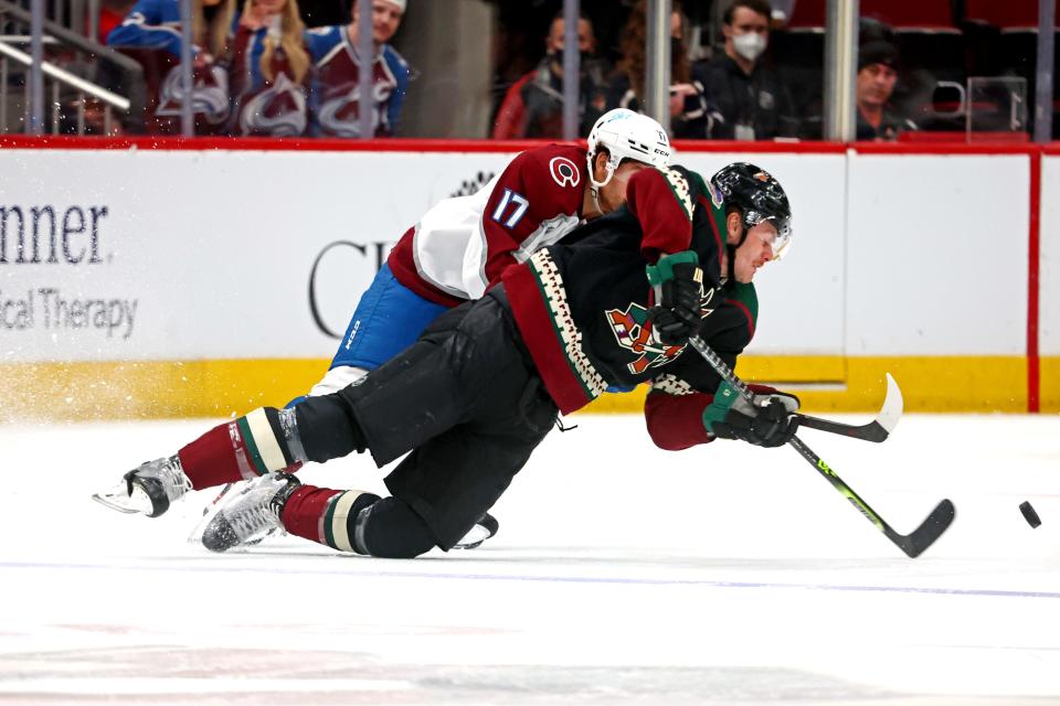 Jan 15, 2022; Glendale, Arizona, USA; Arizona Coyotes left wing Lawson Crouse (67) and Colorado Avalanche center Tyson Jost (17) go for the puck during the second period at Gila River Arena. Mandatory Credit: Mark J. Rebilas-USA TODAY Sports