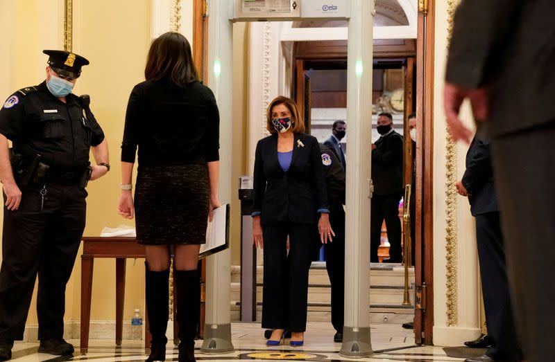 FILE PHOTO: U.S. House Speaker Nancy Pelosi (D-CA) walks through a new metal detector outside the House chamber at the U.S. Capitol