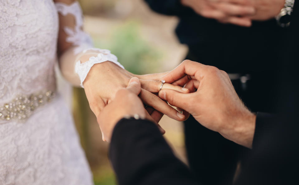 Stock picture of couple exchanging rings at a wedding ceremony. (Getty Images)