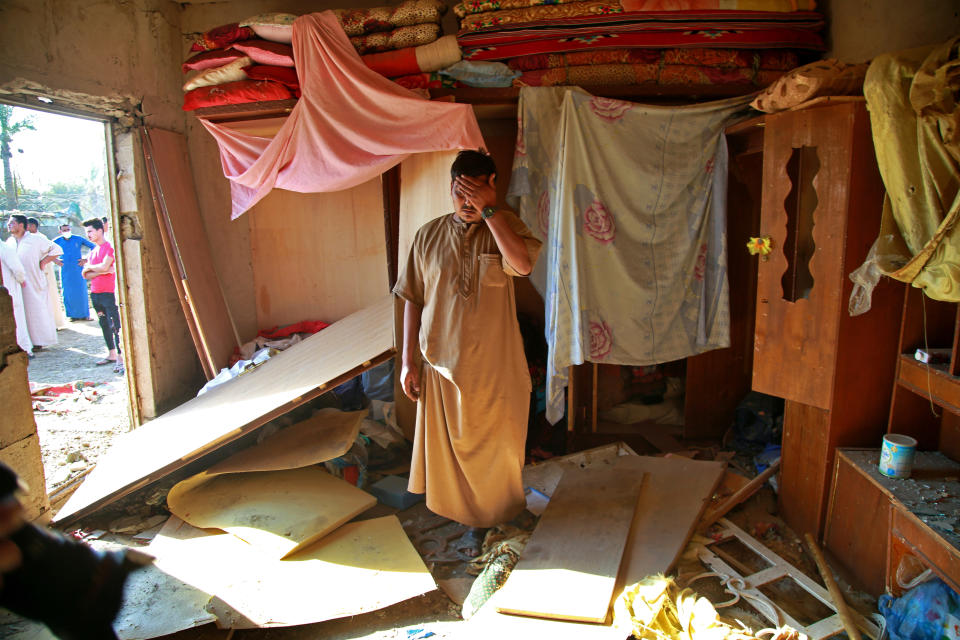 A man inspects the aftermath of a deadly Katyusha rocket attack inside his home near the international airport in Baghdad, Iraq, Tuesday, Sept. 29, 2020. Several Iraqi civilians were killed and two severely wounded Monday after the Katyusha rocket hit near Baghdad airport, Iraq military said. It was the first time in months an attack caused civilian casualties. (AP Photo/Khalid Mohammed)