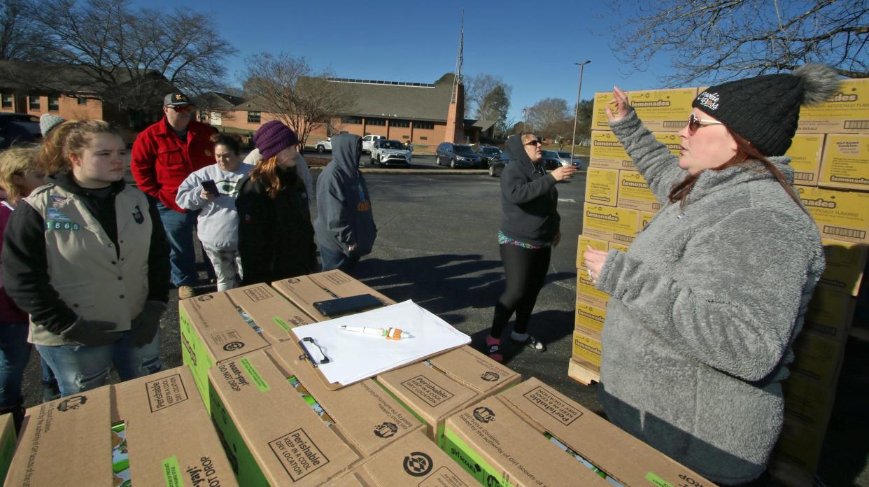 Jenny Griffin lets everyone know the procedure for picking up cookies after several pallets of Girl Scout cookies were unloaded early Saturday morning, Jan. 13, 2024, in the parking lot of Aldersgate UMC in Shelby.