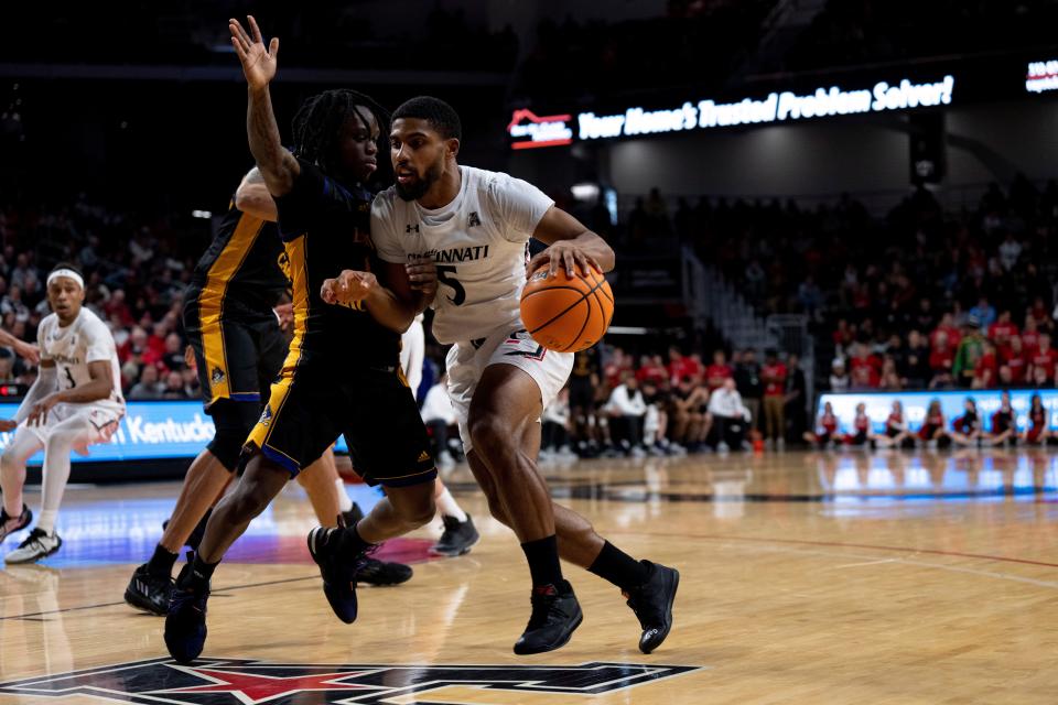 Cincinnati Bearcats guard David DeJulius (5) drives on East Carolina Pirates guard Kalib LaCount (1). DeJulius finished with 11 points and 12 assists in UC's victory.