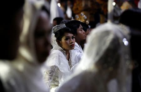 Couples take part in a mass wedding organised by the city government as part of New Year's Eve celebrations in Jakarta, Indonesia, December 31, 2017. REUTERS/Darren Whiteside