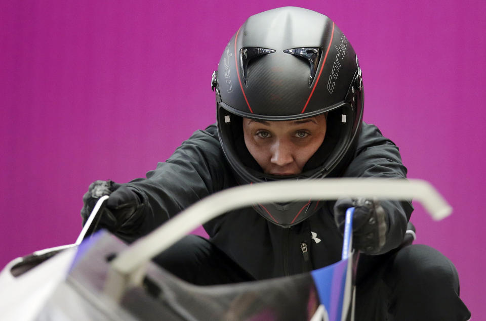 FILE - In this Sunday, Feb. 16, 2014, file photo, breakman Lolo Jones, of the United States, prepares for a training session with her teammate Jazmine Fenlator for the women's bobsleigh at the 2014 Winter Olympics, in Krasnaya Polyana, Russia. Jones hasn’t returned to China since 2008, since one bad step in what was then the biggest race of her life cost her an Olympic gold medal. Her stance might change in 2022. (AP Photo/Michael Sohn, File)