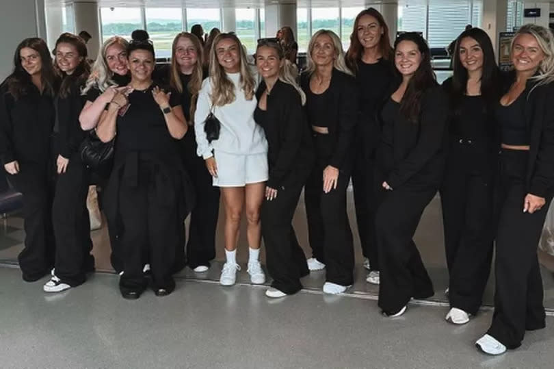 The huge group got a picture together in the airport