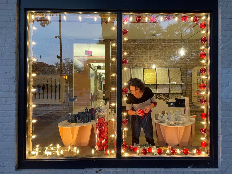 Nicolette Vira, the retail manager for Decree Company, a custom printing and gift shop on E. Martin Street decorates a store window over looking Moore Square for the Holiday season on November 8, 2022 in Raleigh, N.C. Decree Company offers in house letter press and engraving of custom designed cards, invitations and announcements on vintage machines. They provide a wide variety of fine specialty gifts from around the world including umbrellas, leather cases, tea sets, writing pens and inks. Robert Willett/rwillett@newsobserver.com