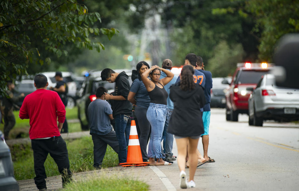 People gather east of YES Prep Southwest Secondary school after a shooting on Friday, Oct. 1, 2021 in Houston. An employee at the Houston charter school was shot and wounded by a former student, police said. Houston Police Chief Troy Finner said a 25-year-old man surrendered after being surrounded by police. (Mark Mulligan/Houston Chronicle via AP)