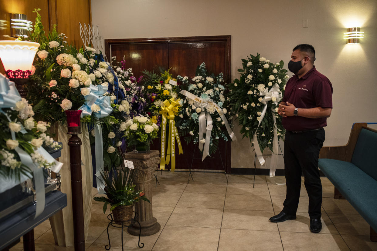 Johnny Salinas júnior, director de una funeraria, supervisa los arreglos de flores para Francisco Tafolla sénior, el tío de su madre, en Salinas Funeral Home en Elsa, Texas, el 21 de julio de 2020. (Tamir Kalifa/The New York Times)