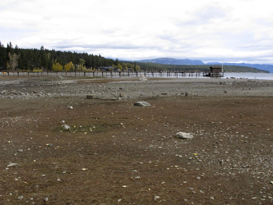 A pier and dock sits above Lake Tahoe's receding shoreline Wednesday, Oct. 20, 2021 in Tahoe City, Calif. Drought fueled by climate change has dropped Lake Tahoe below its natural rim and halted flows into the Truckee River, an historically cyclical event that's occurring sooner and more often than it used to _ raising fears about what might be in store for the famed alpine lake. (AP Photo/Scott Sonner).