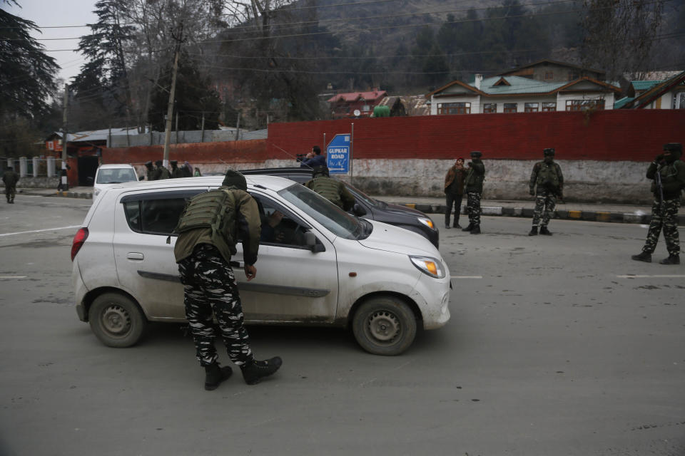 An Indian paramilitary soldier stops civil vehicles as a convoy of New Delhi-based diplomats passes through Srinagar, Indian controlled Kashmir, Thursday, Jan. 9, 2020. Envoys from 15 countries including the United States are visiting Indian-controlled Kashmir starting Thursday for two days, the first by New Delhi-based diplomats since India stripped the region of its semi-autonomous status and imposed a harsh crackdown in early August. (AP Photo/Mukhtar Khan)