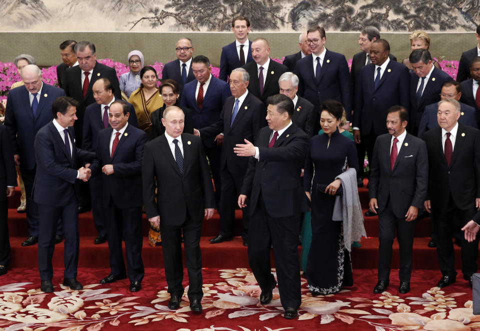 FILE - Chinese President Xi Jinping and his wife Peng Liyuan, front center, attend a group photo session with other leaders at a welcoming banquet for the Belt and Road Forum at the Great Hall of the People, in Beijing, on April 26, 2019. China's Belt and Road Initiative looks to become smaller and greener after a decade of big projects that boosted trade but left big debts and raised environmental concerns. (Jason Lee/Pool Photo via AP, File)