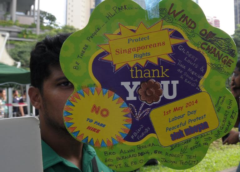 A man reads a placard displayed at speakers corner during a labour day protest in Singapore, on May 1, 2014