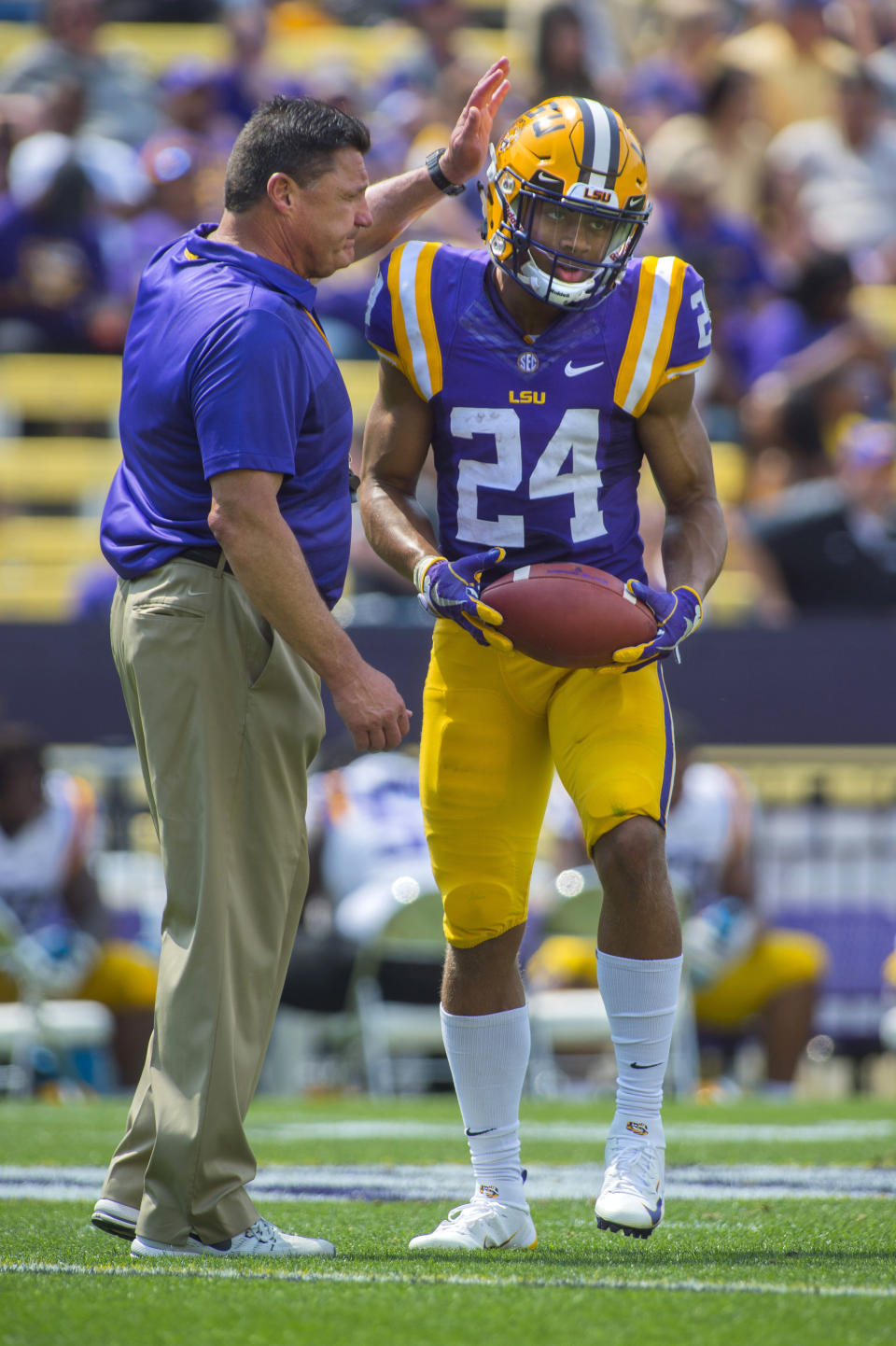FILE - In this April 6,2019, file photo, LSU coach Ed Orgeron, left, gives freshman cornerback Derek Stingley Jr. (24) a pat on the head after talking with him briefly after Stingley fielded a punt during the NCAA college football team's spring scrimmage n Baton Rouge, La. Stingley was the nation’s No. 1 prospect in his class according to Rivals and was rated third according to the 247Sports Composite. Travis Spradling/The Advocate via AP, File)
