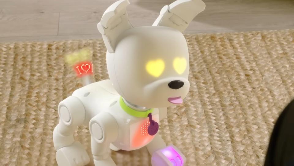 A white robotic dog with yellow heart-shaped eyes